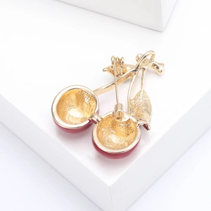 Detailed back view of the cherry brooch showing the golden pin fastener and enamel finish