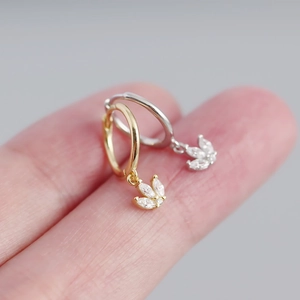 Macro shot of gold and silver hoop earrings with marquise cubic zirconia floral drops