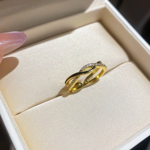 Close-up of elegant gold-plated infinity ring with cubic zirconia paving in a jewelry box