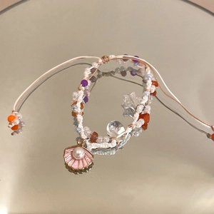 Detailed macro shot of handmade woven starfish beaded bracelet on a reflective mirror base
