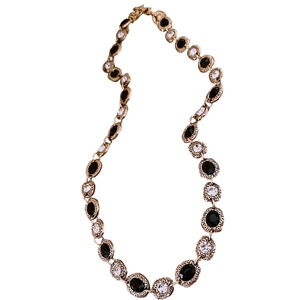 Vintage gold oval necklace with black gemstone and zircon accents on a white background