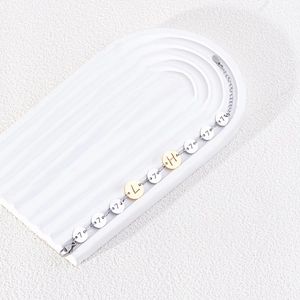 Dettaglio del bracciale in acciaio inossidabile bicolore con lettere e numeri incisi