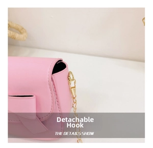 Detail of detachable gold metal hook and pink PU leather strap on a girls handbag