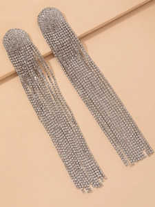 Détail de strass étincelants sur d'élégantes boucles d'oreilles à longs pompons en argent
