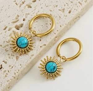 Detailed macro view of bohemian sunburst gold earrings with turquoise center stone