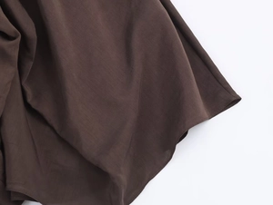 Détail macro de la jupe midi marron foncé avec tissu haute densité et ourlet cousu ondulé