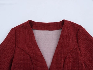 Detailed macro view of the dark red tweed dress neckline with sharp V-neck design