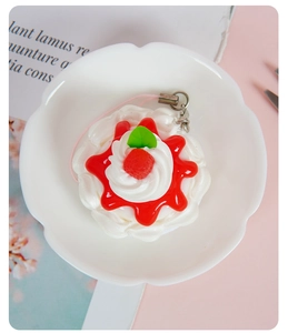 Detailed top view of a realistic mini strawberry cream cake pendant on a white plate