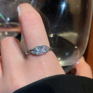 Detailed view of silver leaf-shaped ring with pavé zircons worn on model finger