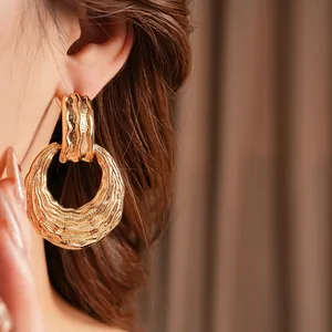 Elegant gold round earrings for women featuring a textured vintage design with light waves