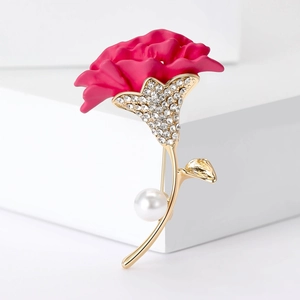 Close-up of pink carnation brooch with rhinestones, golden stem and a white pearl detail
