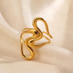 Bague ouverte dorée ondulée minimaliste sur fond de tissu en soie plissée beige
