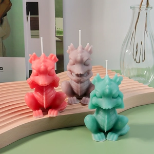 Detailed trio of dragon candle sculptures in red, purple, and green on wood tray