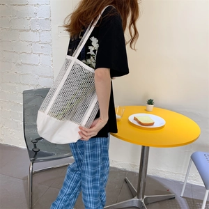 Close-up of white mesh tote bag with canvas stitching and spacious interior for summer