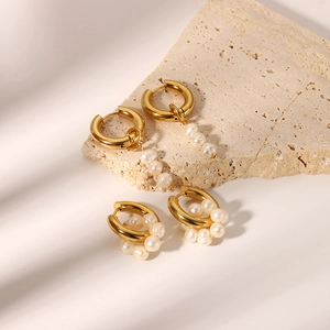 Détail de créoles dorées à l'or 18 carats ornées de perles d'eau douce naturelles