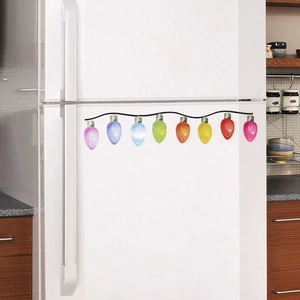 Close-up of colorful magnetic Christmas bulb stickers on a white refrigerator door