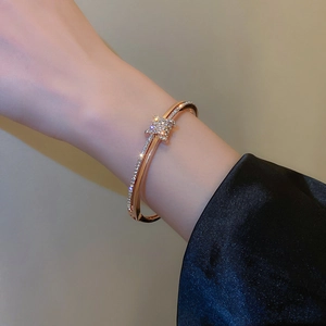 Detail of rose gold open bracelet with pave-set crystals and dual-layer structure
