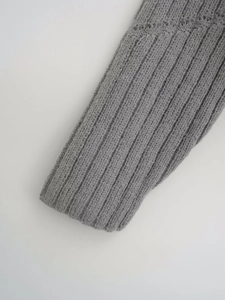 Close-up of grey knit sweater showing detailed vertical ribbed texture and premium fabric