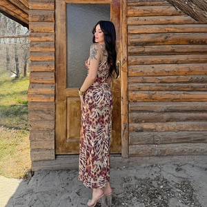 Side view of backless leopard print maxi dress with thin straps against a wooden background