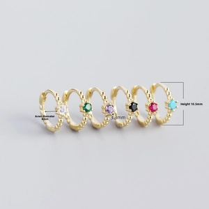 Detail view of 8mm inner diameter gold huggie earrings with colorful 3.3mm crystals