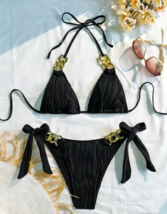 Detail of black ribbed bikini with decorative gold chains on halter straps and side ties