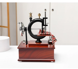 Close-up of vintage sewing machine music box with red plaid fabric and metal scissors
