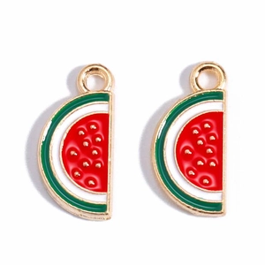 Macro detail of two red enamel watermelon slice charms with gold alloy metal edges