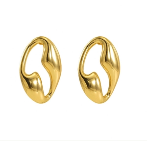 Detail of high-polished gold geometric earrings with irregular organic hollow design