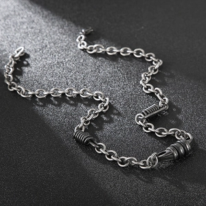 Retro stainless steel O-chain necklace with textured cylinder pendants on black background