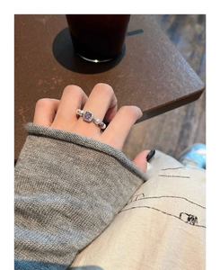 Detailed view of an elegant purple zircon ring with pearls worn on a woman's finger