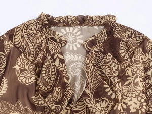 Detailopname van de bohemian ruches halslijn met paisley-print op chiffon stof