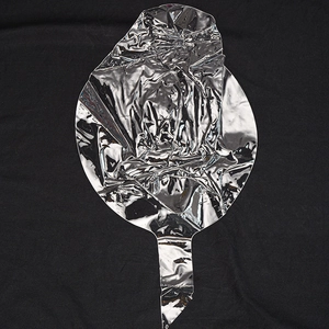 Flat lay of uninflated silver aluminum foil balloon with metallic finish on black background