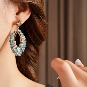 Gros plan de boucles d'oreilles losange bohème avec perles bleues et zircons