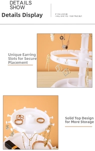 Close-up of rotating jewelry organizer showing hooks for earrings and necklaces