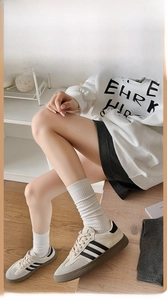 Detailed close-up of a white cotton ribbed crew sock showing natural stack effect on foot