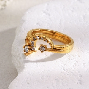 Macro detail of 18K gold moon ring with sparkling crystals on textured stone base