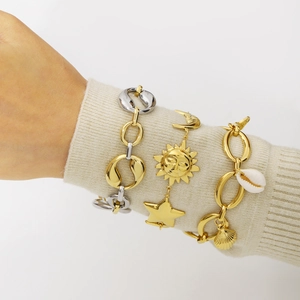 Minimalist gold and silver bracelets featuring star, moon, and shell pendants on model