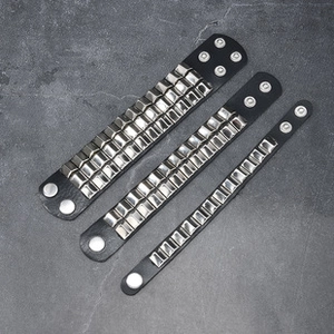 Detailed view of three punk leather bracelets with silver studs and snap button closures