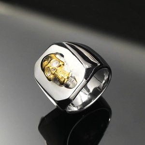 Macro shot of two-tone silver and gold skull ring for men with sharp metallic reflection