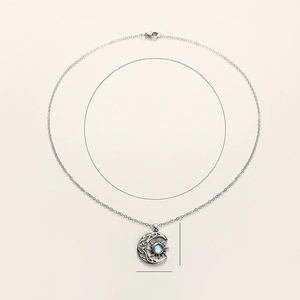 Macro detail of vintage silver moon and sun necklace with Celtic knot and moonstone