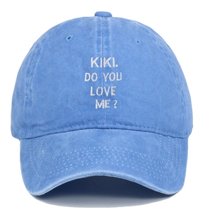 Dettaglio del ricamo KIKI bianco su cappello da baseball vintage in cotone lavato blu