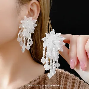 Orecchini lunghi con nappe bianche e perline floreali testurizzate da donna