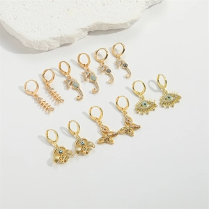 Golden sea life earrings set featuring seahorse and fishbone charms with blue crystals