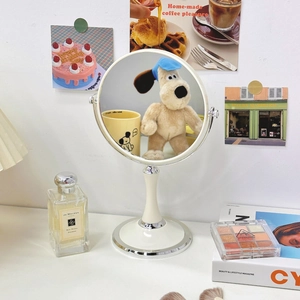 Minimalist round wooden vanity mirror for desktop with a steady white base in a home setting