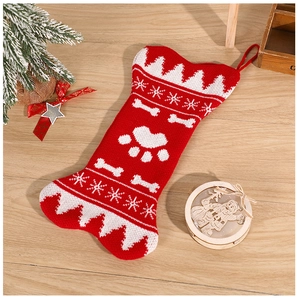 Close-up of red and white knitted bone-shaped Christmas stocking with snowflake patterns