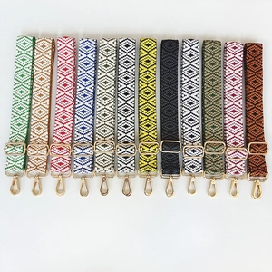 Detail of colorful geometric jacquard bag straps with golden metal swivel hooks