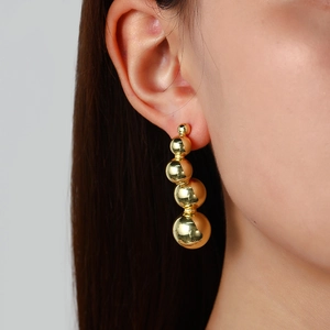 Detail view of 18k gold plated hollow spheres on earlobe with high polished mirror finish