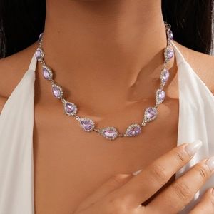 Close-up of elegant purple teardrop pendant necklace worn on neck with silver chain