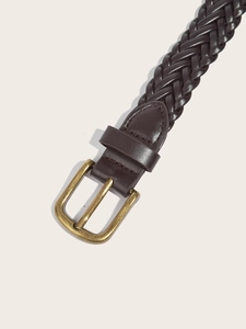 Detail of dark brown braided leather belt featuring a vintage brass buckle and leather loop
