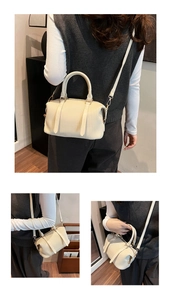 Detail of off-white pleated Boston bag showing wavy texture and round top handles